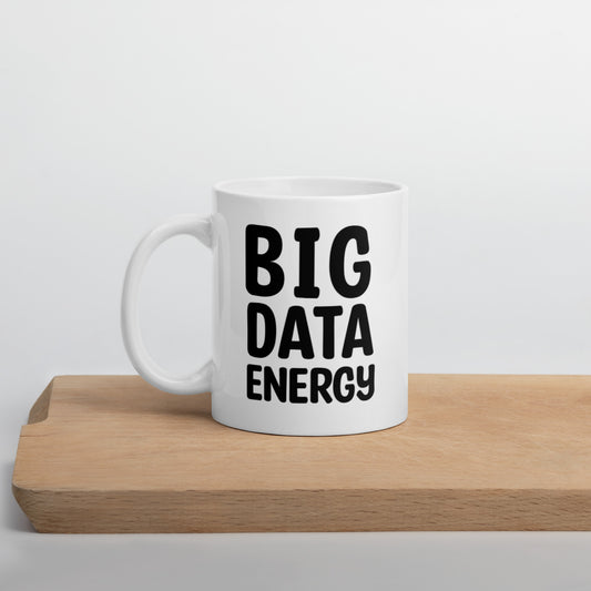 A glossy white ceramic mug with bolded black bubble text that reads 'BIG DATA ENERGY', positioned on a wooden cutting board against a neutral background.